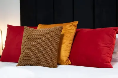 a group of four pillows sitting on a bed at 2 Bedroom in the Heart of Loch Lomond in Balloch