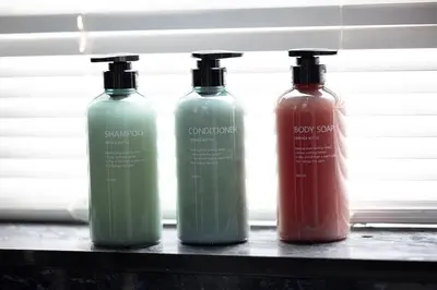 three bottles of detergent sitting on a shelf at 2 Bedroom in the Heart of Loch Lomond in Balloch