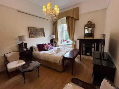 a living room with a bed and a fireplace at Wonderful 3 Bed West End Flat in Glasgow
