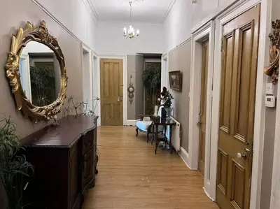 a hallway with a mirror and a table in a room at Wonderful 3 Bed West End Flat in Glasgow