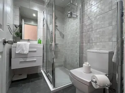 a white bathroom with a shower and a toilet at Wonderful 3 Bed West End Flat in Glasgow