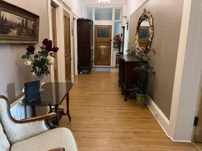 a hallway with a table and chairs and a mirror at Wonderful 3 Bed West End Flat in Glasgow