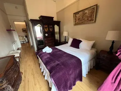 a bedroom with a large bed with a purple blanket at Wonderful 3 Bed West End Flat in Glasgow