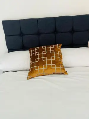 a brown pillow sitting on top of a bed at Lovely spacious home near station in Moffat