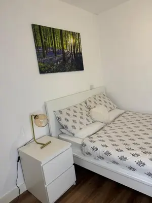 a white bed in a room with a night stand at Welcome to Home Away From home in Moffat