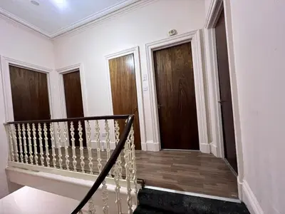 a staircase in a house with wooden doors at Cheerful 5 Bedroom House Close to Central West End and Parking in Glasgow