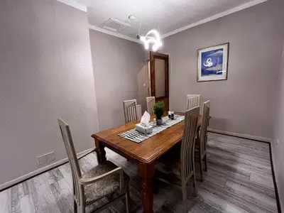 a dining room with a wooden table and chairs at Cheerful 5 Bedroom House Close to Central West End and Parking in Glasgow