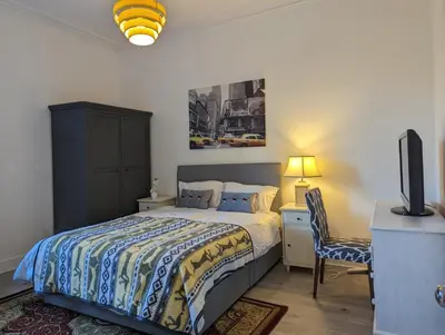a bedroom with a bed and a desk and a tv at 2 Bedroom Flat in Edinburgh City in Edinburgh
