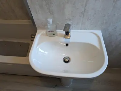 a white sink in a bathroom with a bottle of soap at 2 Bedroom Flat in Edinburgh City in Edinburgh