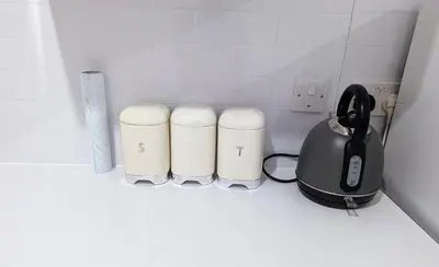 a tea kettle and two cups on a counter at 2 Bedroom Flat in Edinburgh City in Edinburgh