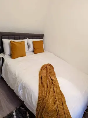 a white bed with yellow pillows and a blanket on it at 2 Bedroom Flat in Edinburgh City in Edinburgh