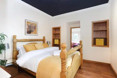 a bedroom with a wooden bed in a room at Greenknowes Entire Private Estate in Kelty