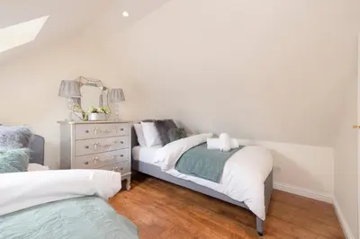a bedroom with two beds and a dresser at Greenknowes Entire Private Estate in Kelty