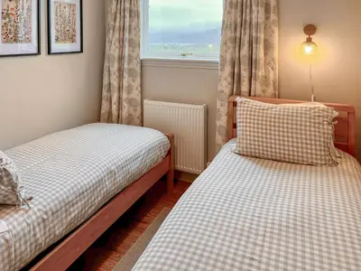 two beds in a room with a window at Ardvenhor in Gartocharn