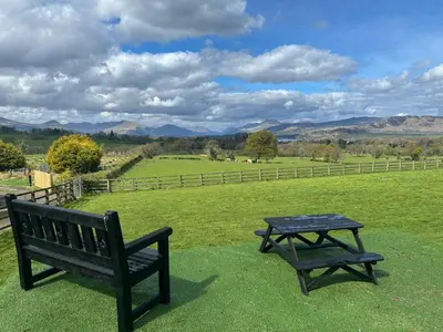 a picnic table and a bench in a field at Ardvenhor in Gartocharn