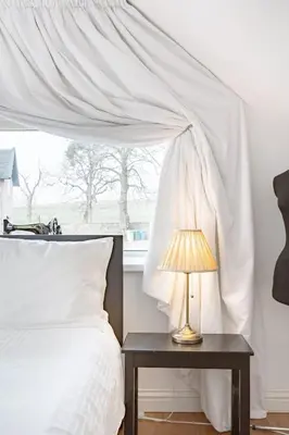 a bedroom with a bed and a table with a lamp at Converted Historical Stone Coach House in Glasgow