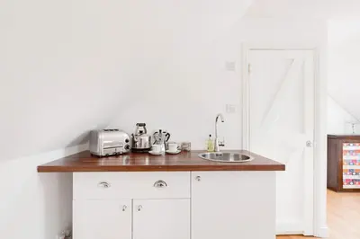 a kitchen with a sink and a counter top at Converted Historical Stone Coach House in Glasgow