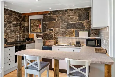 a kitchen with a counter and a stone wall at Stunning 1Bedroom Central Apartment in Oban