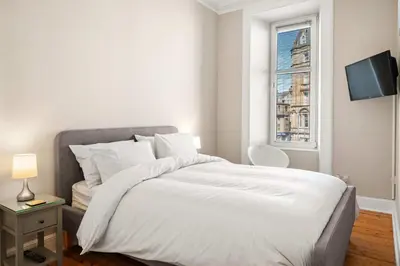 a white bedroom with a bed and a window at Stunning 1Bedroom Central Apartment in Oban