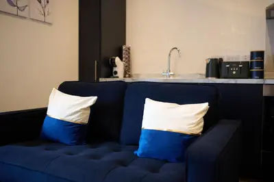 a blue couch with two pillows on it in a kitchen at Modern & Central 1BR Flat with Sky TV in Oban