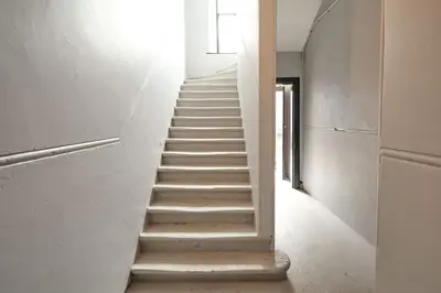 a staircase in a building with white walls and ceilings at Modern & Central 1BR Flat with Sky TV in Oban