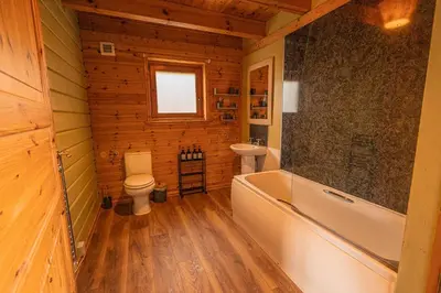 a bathroom with a tub and a toilet and a sink at Lodge 1 in Stirling