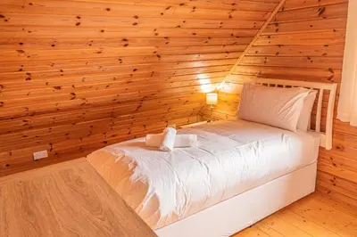 a bedroom with a bed in a wooden wall at Lodge 1 in Stirling