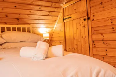 a bedroom with a bed in a log cabin at Lodge 2 in Stirling