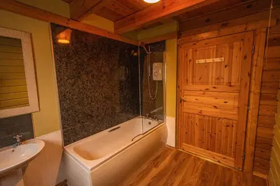 a bathroom with a tub and a sink and a toilet at Lodge 2 in Stirling