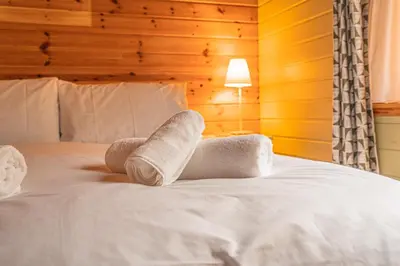 a pair of towels sitting on top of a bed at Lodge 3 in Stirling