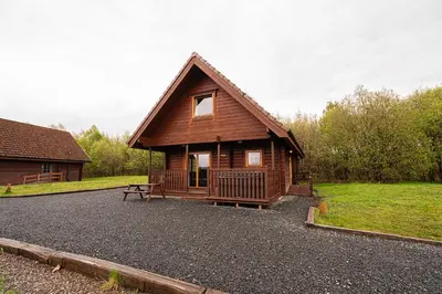 a log cabin with a bench in front of it at Lodge 4 in Stirling