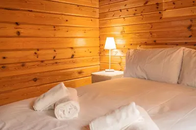 a bedroom with a bed in a wooden room at Lodge 4 in Stirling