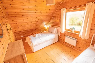 a bedroom with a bed in a log cabin at Lodge 4 in Stirling