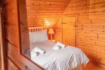 a bedroom with a bed in a wooden cabin at Lodge 5 in Stirling