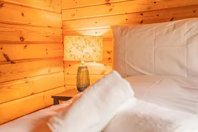 a bedroom with a bed and a lamp on a table at Lodge 5 in Stirling