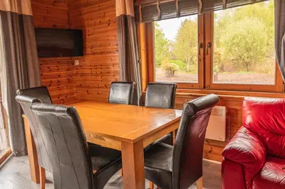 a dining room with a wooden table and chairs at Lodge 6 in Stirling