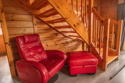 a red chair and a stool in a attic at Lodge 6 in Stirling