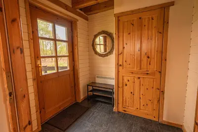 a hallway with a wooden door and a window at Lodge 6 in Stirling