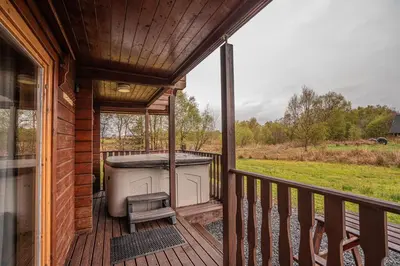 a screened in porch with a tub on a deck at Lodge 6 in Stirling