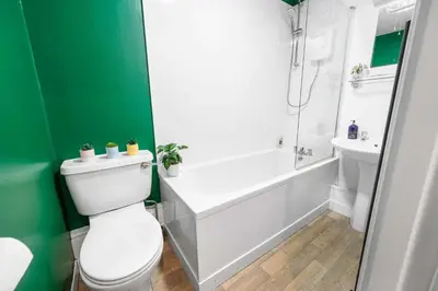 a bathroom with a toilet and a tub and a sink at Modern 1BR Apartment - Close to ferry terminal with free parking in Oban