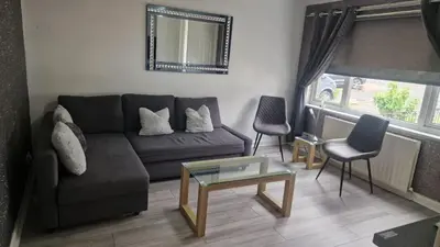 a living room with a couch and two chairs at My Glasgow House Robroyston in Hogganfield