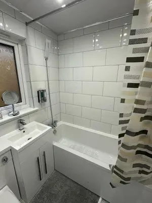 a bathroom with a white tub and a sink at My Glasgow House Robroyston in Hogganfield