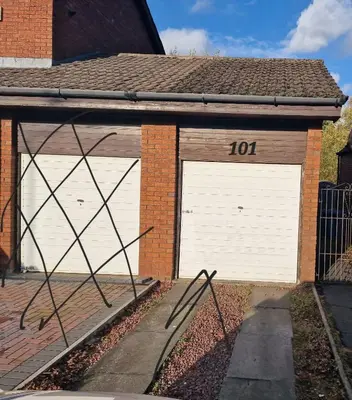 two white garage doors on a brick house at My Glasgow House Robroyston in Hogganfield