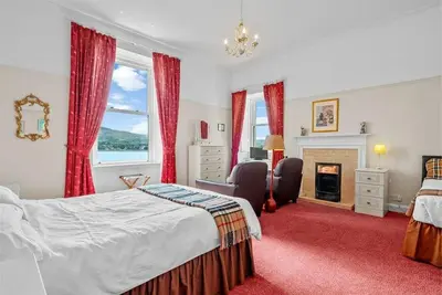 a bedroom with a bed and a fireplace at Rosemount in Campbeltown