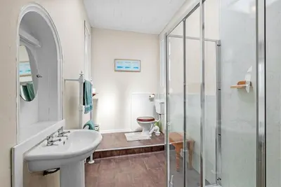 a white bathroom with a sink and a shower at Rosemount in Campbeltown
