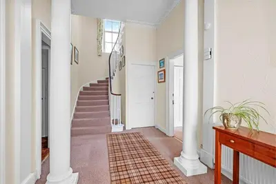 a hallway with white columns and a staircase in a house at Rosemount in Campbeltown