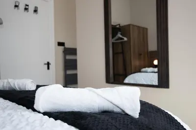 a bedroom with white towels on a bed and a mirror at The White House near Edinburgh in Bathgate