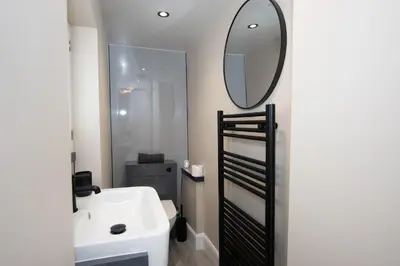 a bathroom with a sink and a mirror on the wall at The White House near Edinburgh in Bathgate