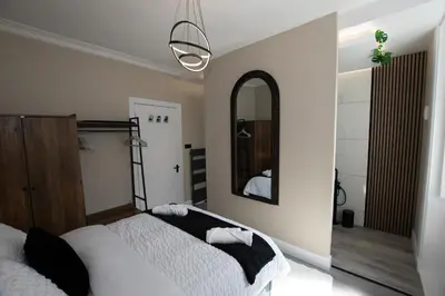 a bedroom with two beds and a mirror at The White House near Edinburgh in Bathgate