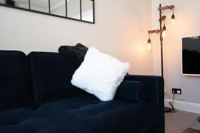 a black couch with a white pillow on it at The White House near Edinburgh in Bathgate